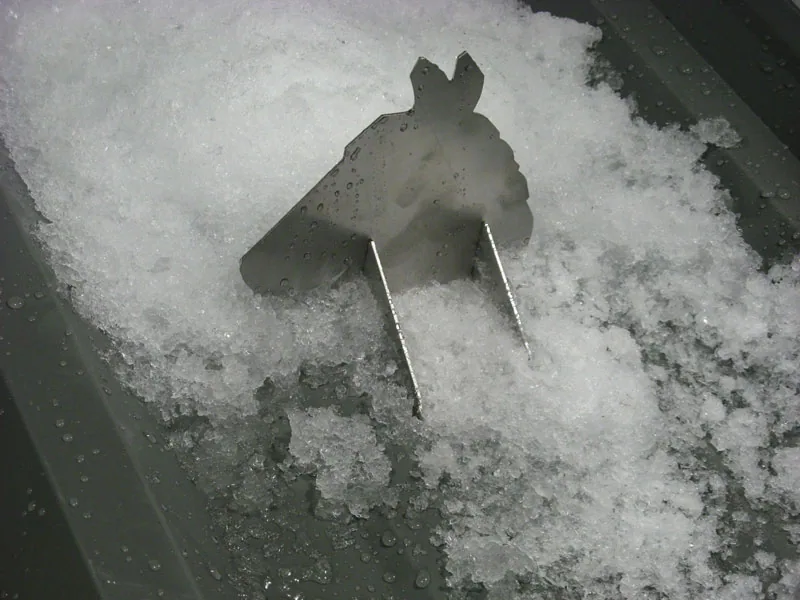 Close view of a strap-mounted snow guard installation on composite roofing