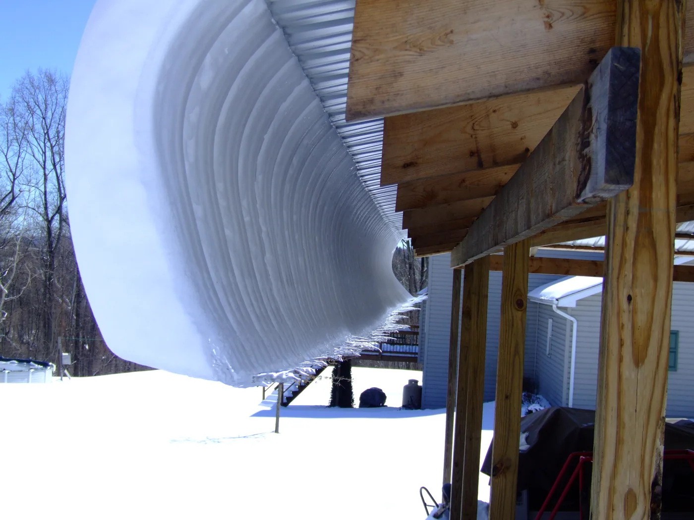 Curling snow forming as snow slowly slides on a metal roof