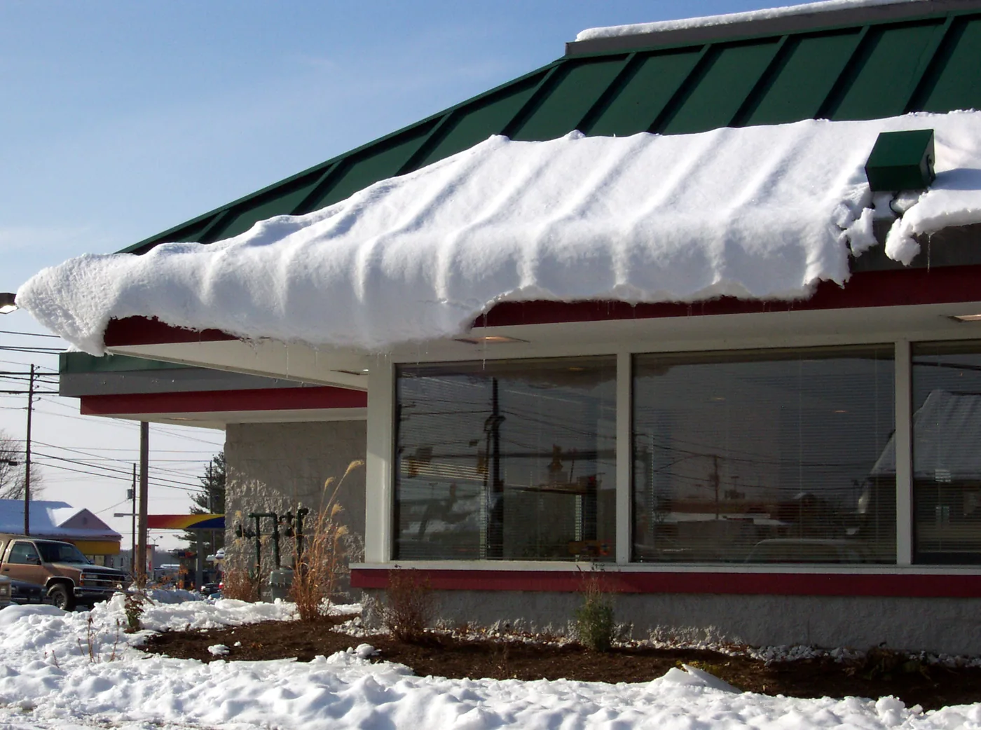The extra overhang of this roof design helps minimize the danger to the windows from this curling snow