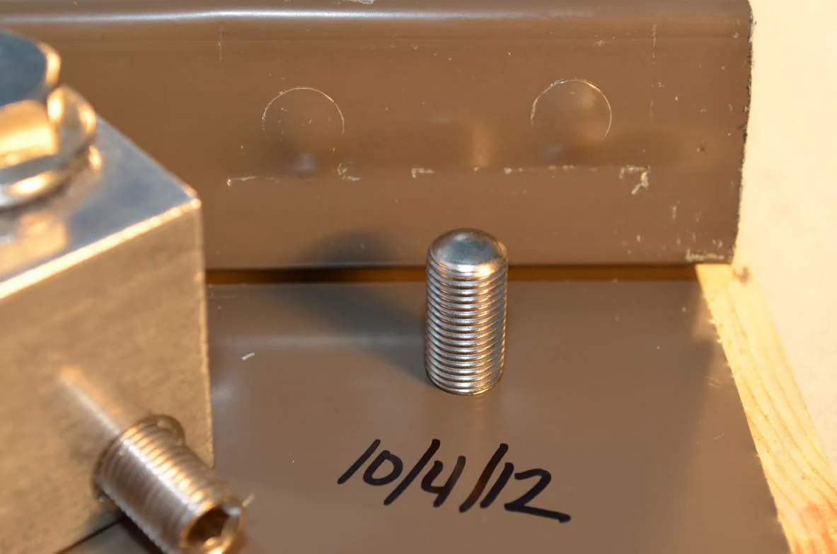 picture shows the permanent seam deformation and paint scratches left behind from using high torque set screws