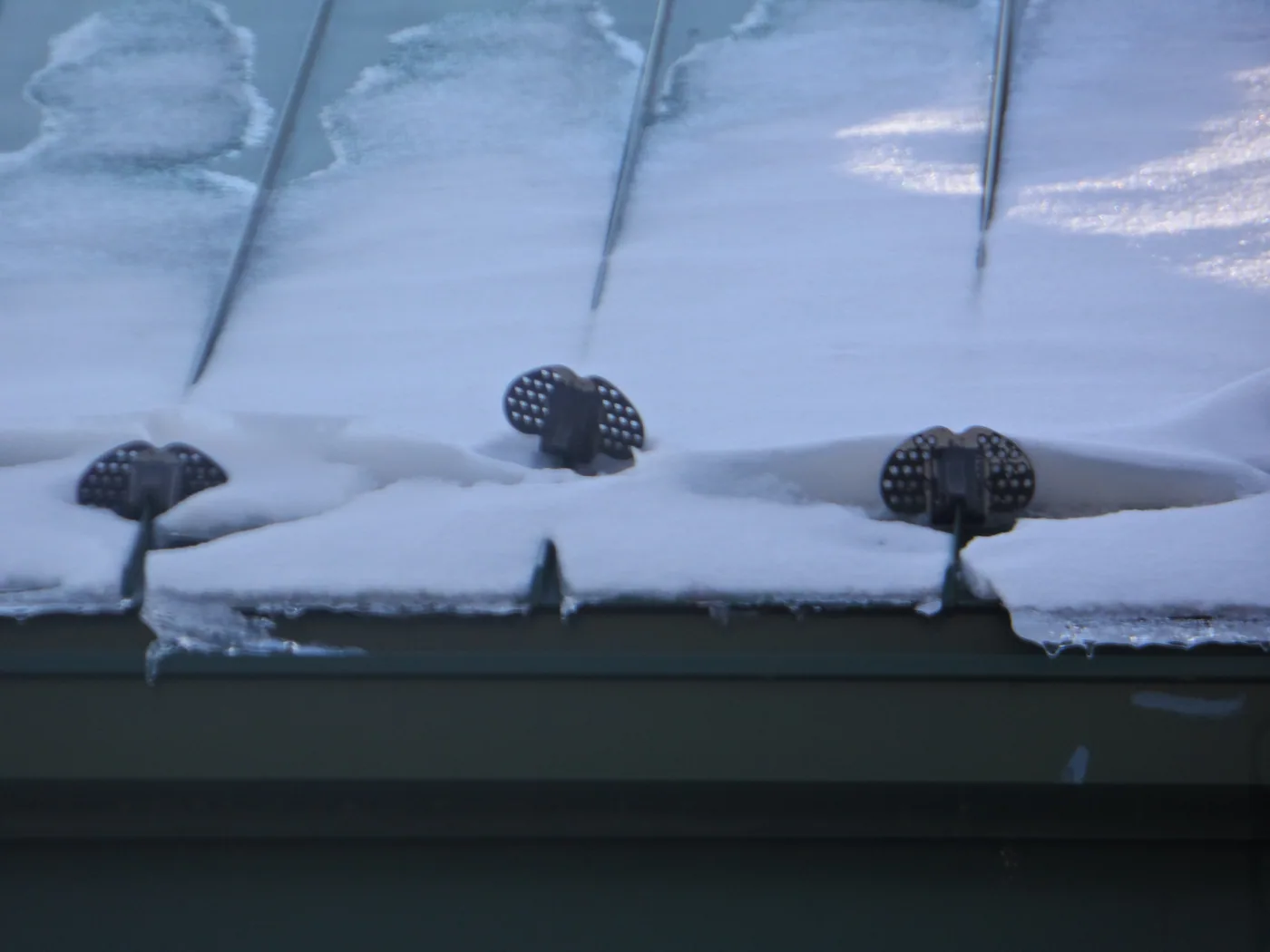 In this illustration of seam mounted snow guards, notice the middle guard has been twisted to the side from uneven loading