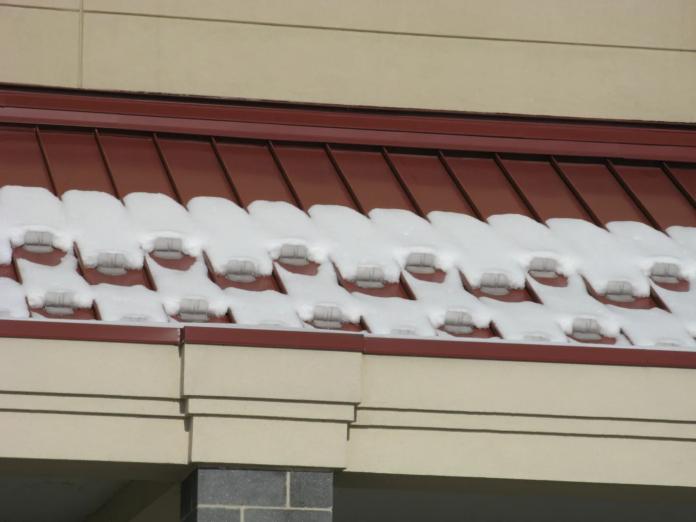 Alternate view of staggered snow guards retaining snow above parked vehicles